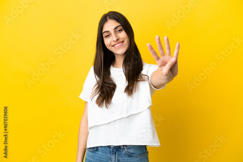 Young caucasian woman isolated on yellow background happy and counting four with fingers © luismolinero