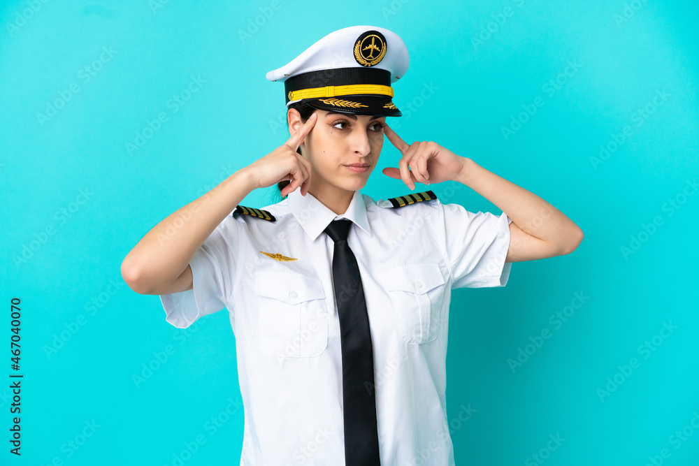 Airplane pilot caucasian woman isolated on blue background having doubts and thinking Airplane pilot caucasian woman isolated on blue background having doubts and thinking