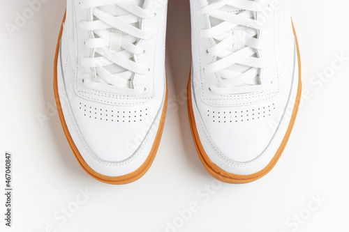 White men's sneakers on white background close-up top view.