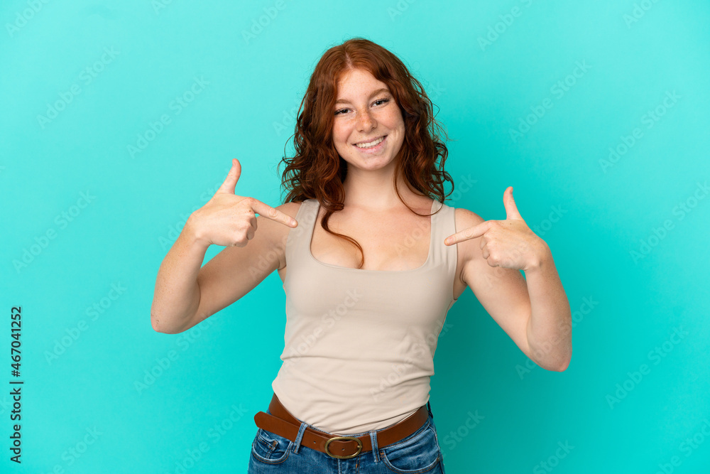 Teenager reddish woman isolated on blue background proud and self-satisfied Teenager reddish woman isolated on blue background proud and self-satisfied