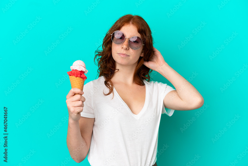 Teenager reddish woman with a cornet ice cream isolated on blue background having doubts Teenager reddish woman with a cornet ice cream isolated on blue background having doubts