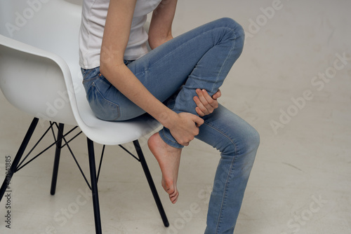 woman sitting on a chair and leg pain joint health problems