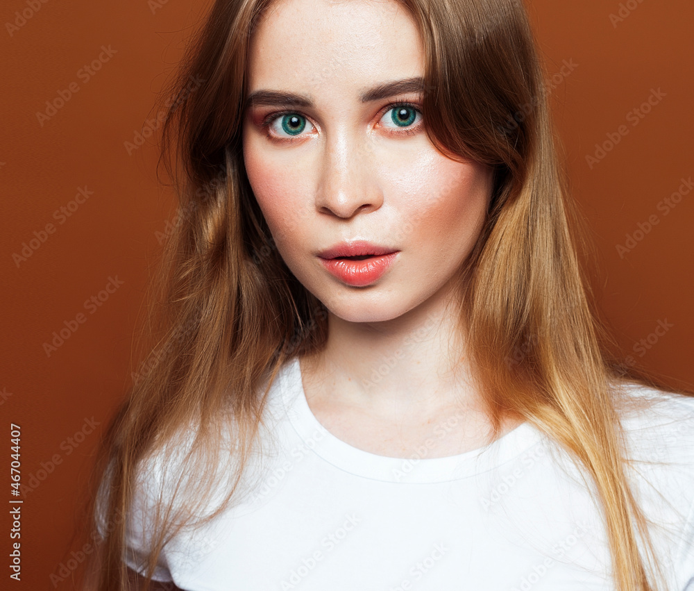 young pretty girl with blond hair posing cheerful on brown background, lifestyle people concept young pretty girl with blond hair posing cheerful on brown background, lifestyle people concept