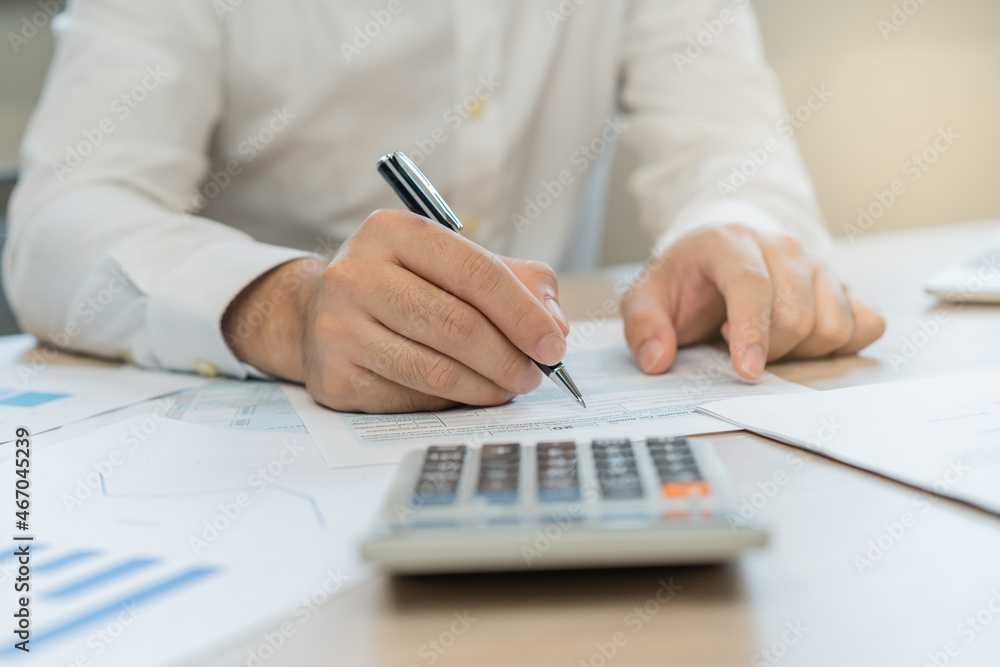 Fototapeta premium Close up hand of stress asian young employee business man, male calculate tax income and expenses, bills, credit card for payment or payday on table at home office. Financial, finance people concept.