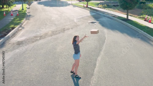 Young woman accepts package delivery by drone. Final mile shipment. Futuristic technology theme. Aerial quadcoper UAV UAS flight. photo