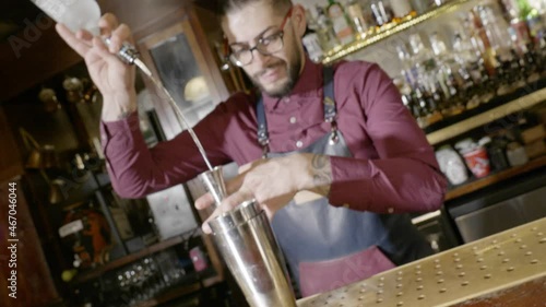 A bartender pouring vodka in the shaker photo