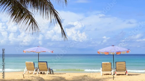 Beach with palm trees and umbrellas to sit and relax on a sunny day at Karon Beach, Phuket, Thailand.	