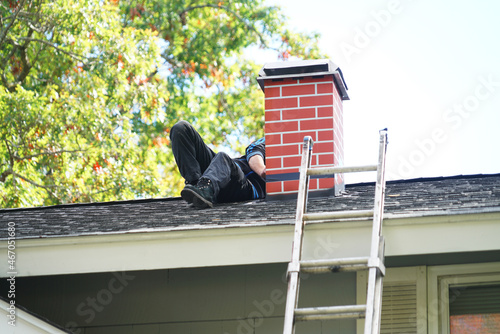 Photo worker repairing chimney on the roof