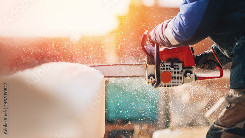 Close-up chainsaw of woodcutter sawing chain saw in motion, sawdust fly to sides. Concept is to bring down trees