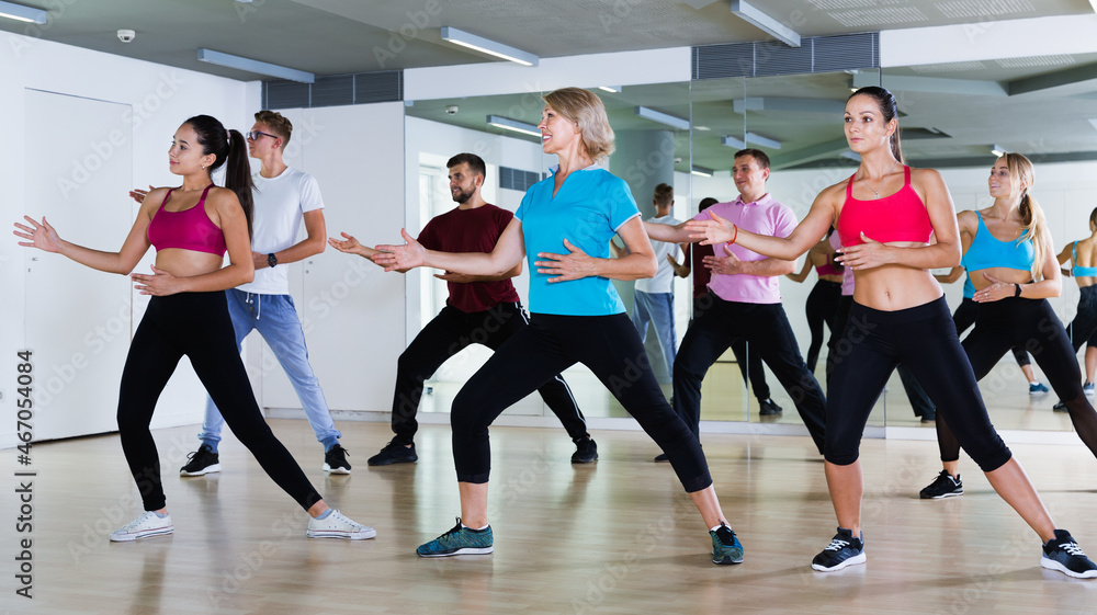 Different ages adults training swing steps at dance class