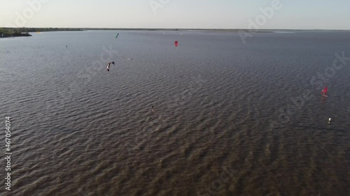 Group of professional Kitesurfer kiteboarding on Vicente Lopez River in Buenos Aires during sunny and windy day,Argentina - Aerial flyover  photo