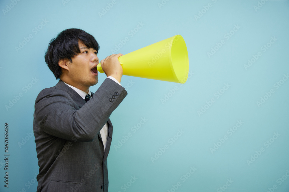 メガホンを持って叫ぶスーツ姿の男性 Stock Photo | Adobe Stock