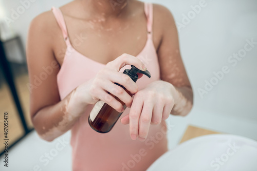 A woman in pink lingerie in a bathroom while doing beauty procedures