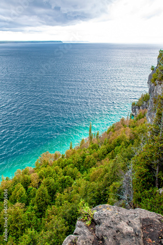 The blue waters of Georgian Bay near Lion's Head, Ontario sit below a tree-lined cliff in Lion's Head Provincial Park on the Bruce Peninsula. photo