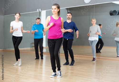 Group of adult people training in gym  doing aerobics exercises
