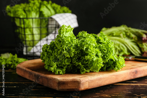 Photos Board with fresh lettuce on dark wooden table