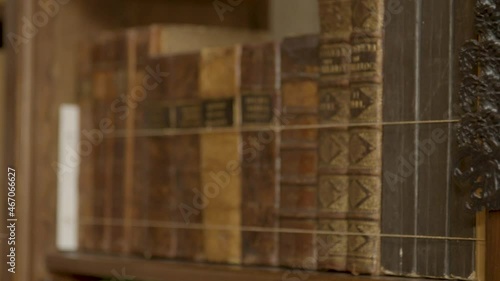 Close pan over collection of old books in luxurious private library