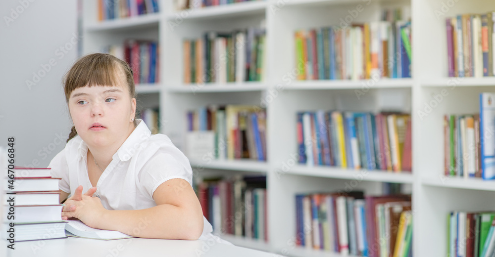Portrait of a smiling girl with syndrome down at library. Empty space for text Portrait of a smiling girl with syndrome down at library. Empty space for text