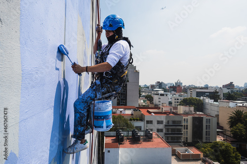 Fotografie Men working on a building using rappelling equipment