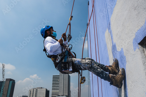 Men working on a building using rappelling equipment photo
