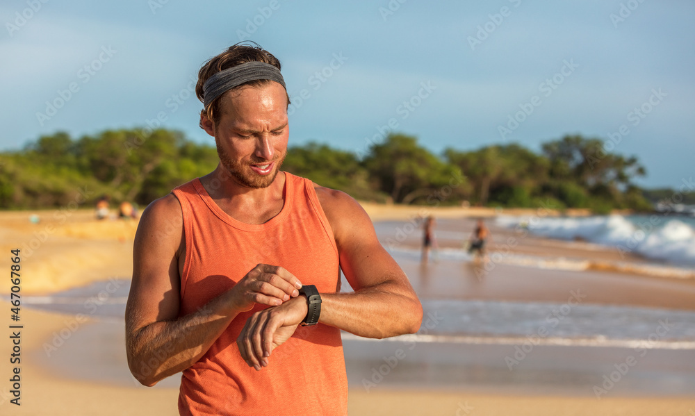 Running man athlete using smartwatch fitness app on wearable tech ...