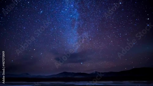 Night shot of the starry sky. Time Laps. The Milky Way moves across the sky in the Sikhote-Alin Nature Reserve with a snake. The motion of the starry sky over a frozen lake.