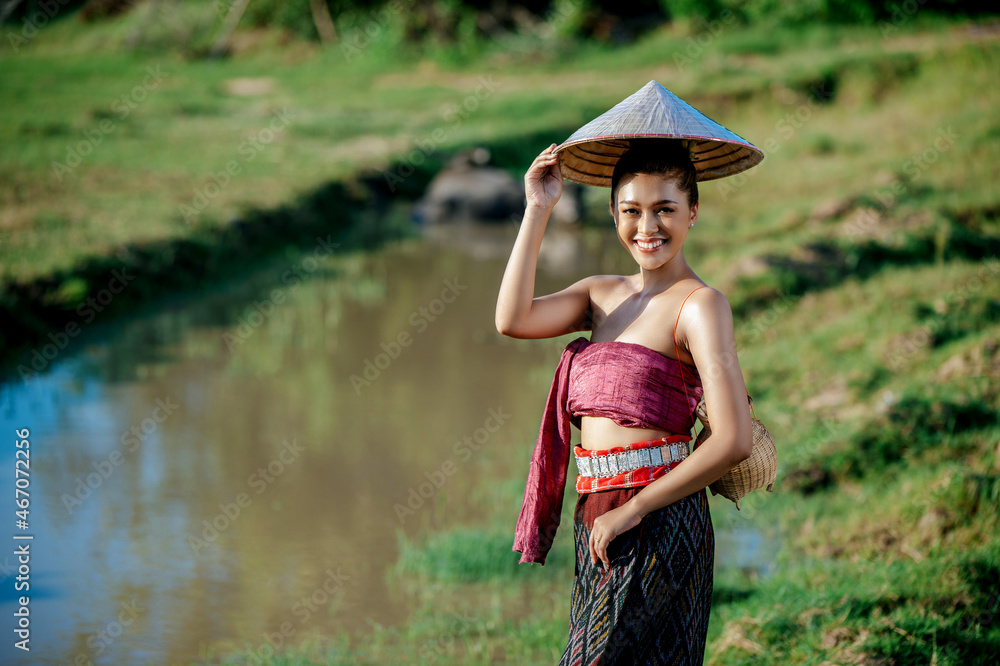 Young woman in beautiful Thai traditional clothes at rice field