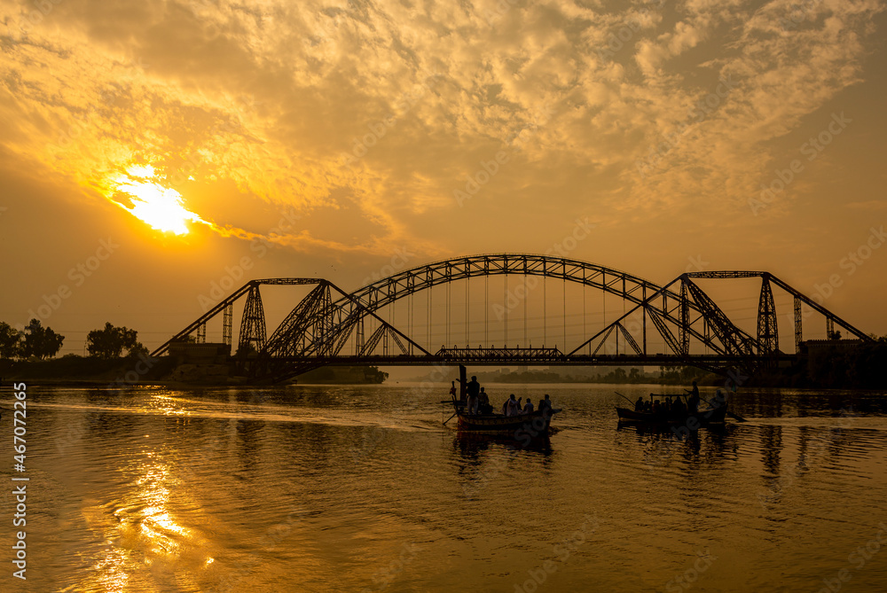 sunset in the river with steel bridge, The Lansdowne Bridge is a 19th-century bridge that spans the Indus River between the cities of Sukkur and Rohri, in the Sindh province of Pakistan.