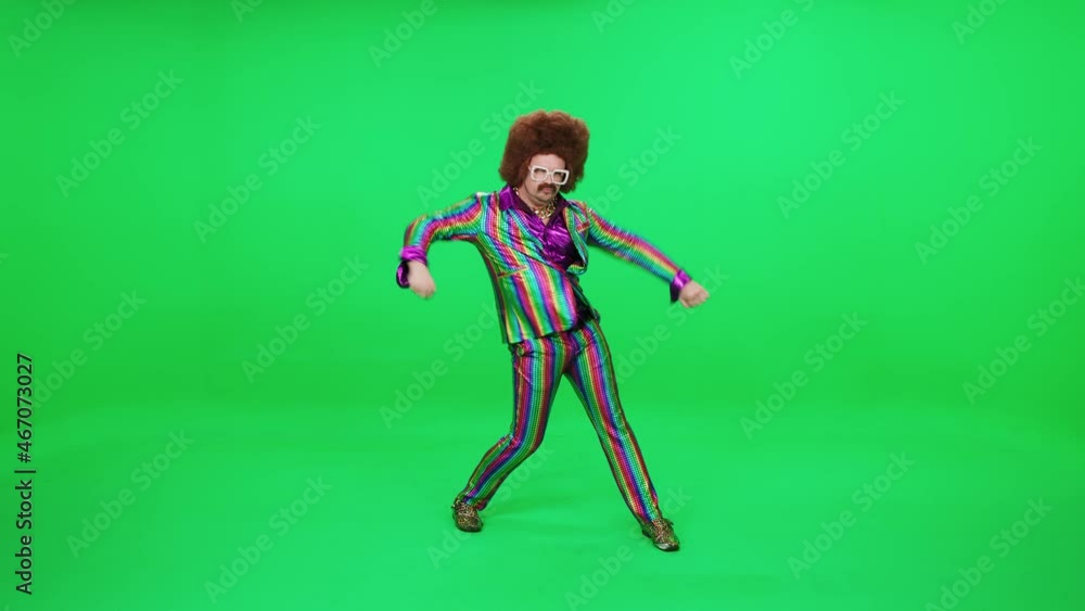 A retro dude in a multicolored suit is dancing a funny dance on a green background, a festive mood, a retro disco man is having fun at a new year's party. A retro dude in a multicolored suit is dancing a funny dance on a green background, a festive mood, a retro disco man is having fun at a new year's party.