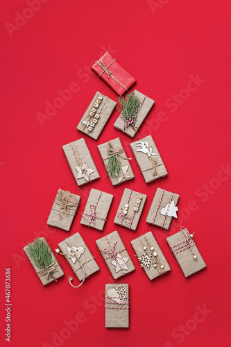 Christmas tree made from gifts. Gift boxes on red background, flat lay. Christmas holiday concept.