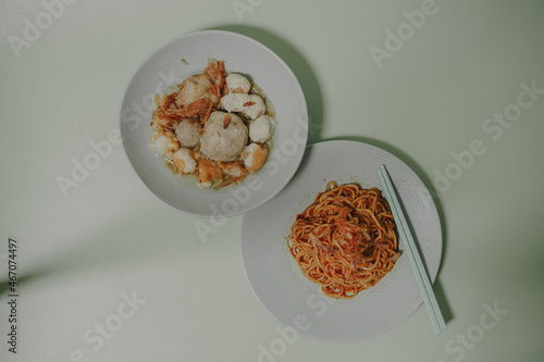 Spicy noodles and meatballs served in Shabby Chic colored bowls and chopsticks photo