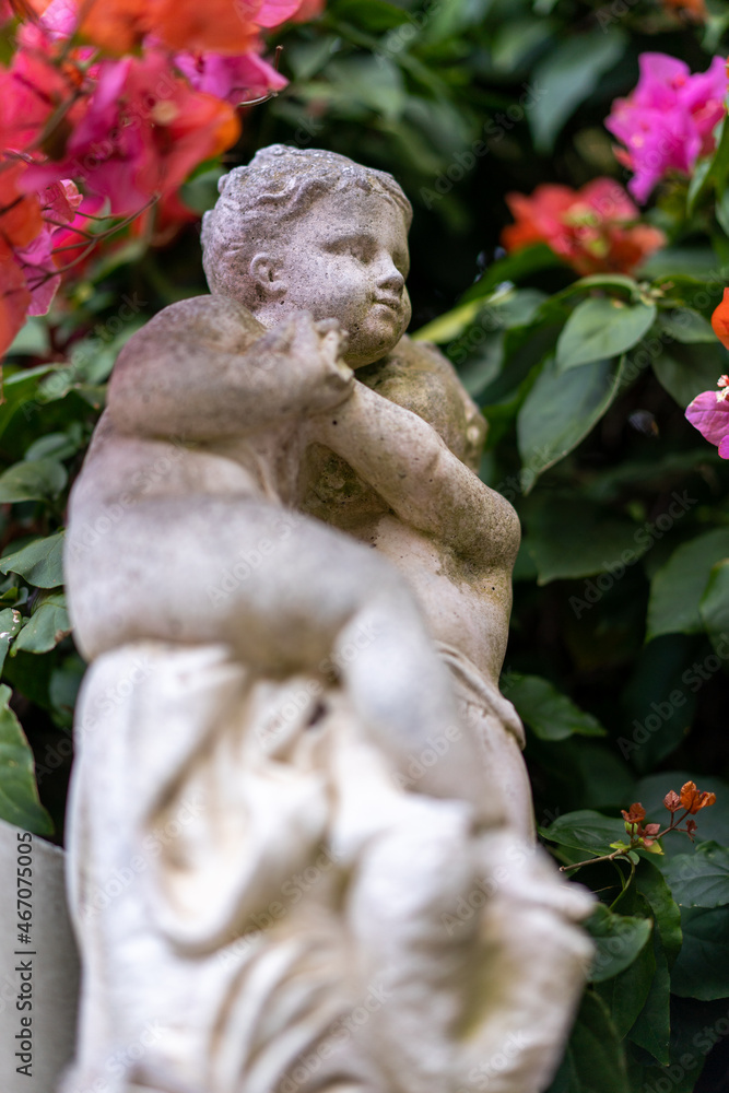 sculpture statue of a small child in outdoor garden area, garden decorations