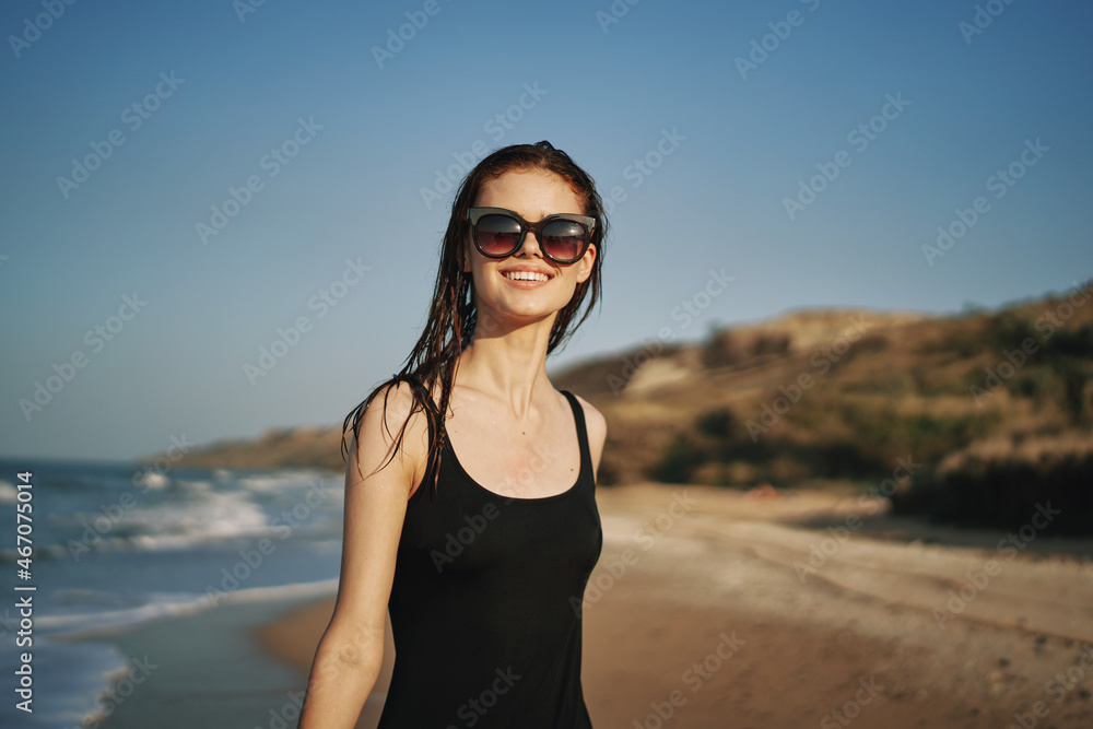 cheerful woman in a black swimsuit walking along the beach tropics summer cheerful woman in a black swimsuit walking along the beach tropics summer