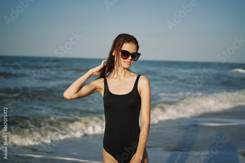 cheerful woman in black swimsuit sunglasses ocean travel