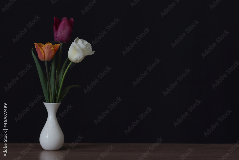Three tulips in a vase on the table. Three tulips in a vase on the table.