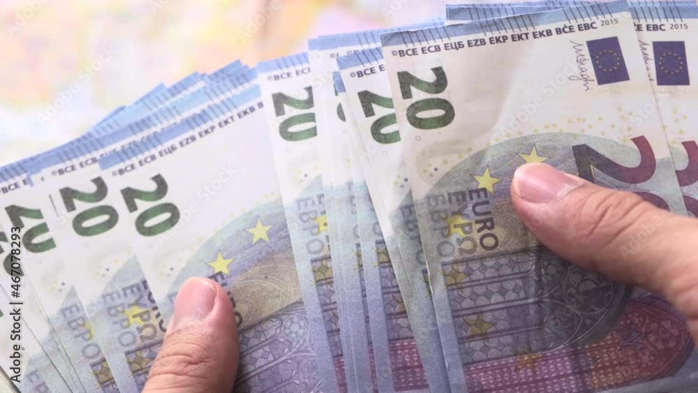 Man holding euro paper currency and counting 20 euro banknotes Man holding euro paper currency and counting 20 euro banknotes