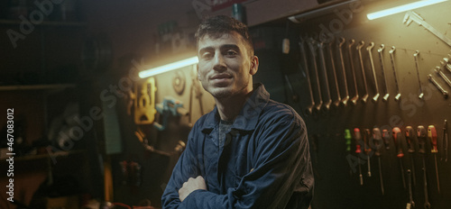 Young blacksmith man with workwear fold one's arms, looking at camera and smiling © mahirkart