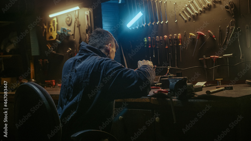 Young blacksmith man with workwear, taking solder tool, sitting on chair and do solder. Young blacksmith man with workwear, taking solder tool, sitting on chair and do solder.