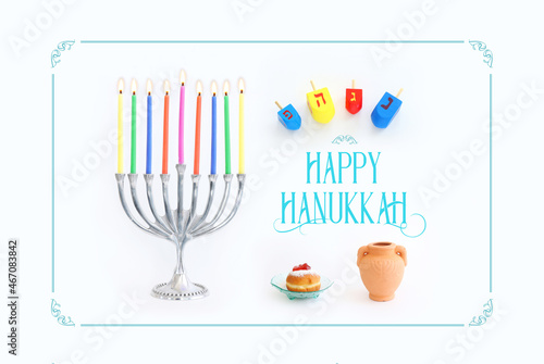 Religion image of jewish holiday Hanukkah background with menorah (traditional candelabra), doughnut and candles over white background