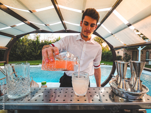 Canvastavla bartender mixing cocktails and drinks outdoor at sunset near a pool in a venue l