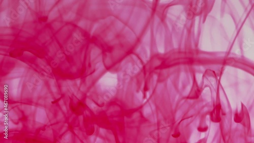 Red pigment ink water explosion from above white background.