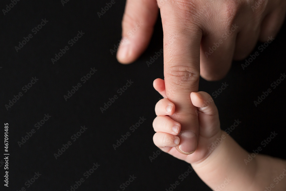 Tiny newborn hand holds father's finger Tiny newborn hand holds father's finger