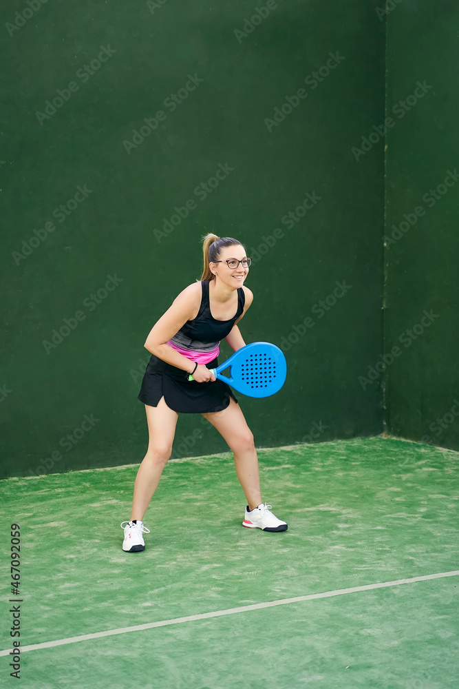 Glad sportswoman ready to play padel