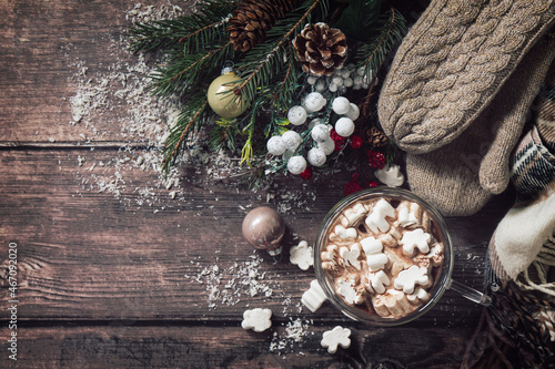 Winter concept. Hot chocolate cacao drink with marshmallows and Christmas present on a wooden table. Top view flat lay background. Copy space.
