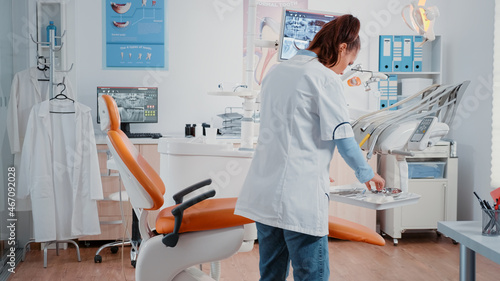 Dentist working with stomatology equipment for dental checkup in cabinet. Woman using tools and chair for oral care and dentistry  preparing for teeth examination in dentist office