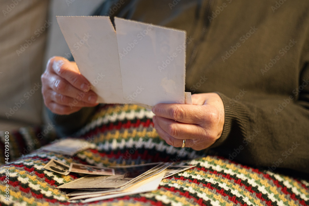 Old woman looking at vintage family photos