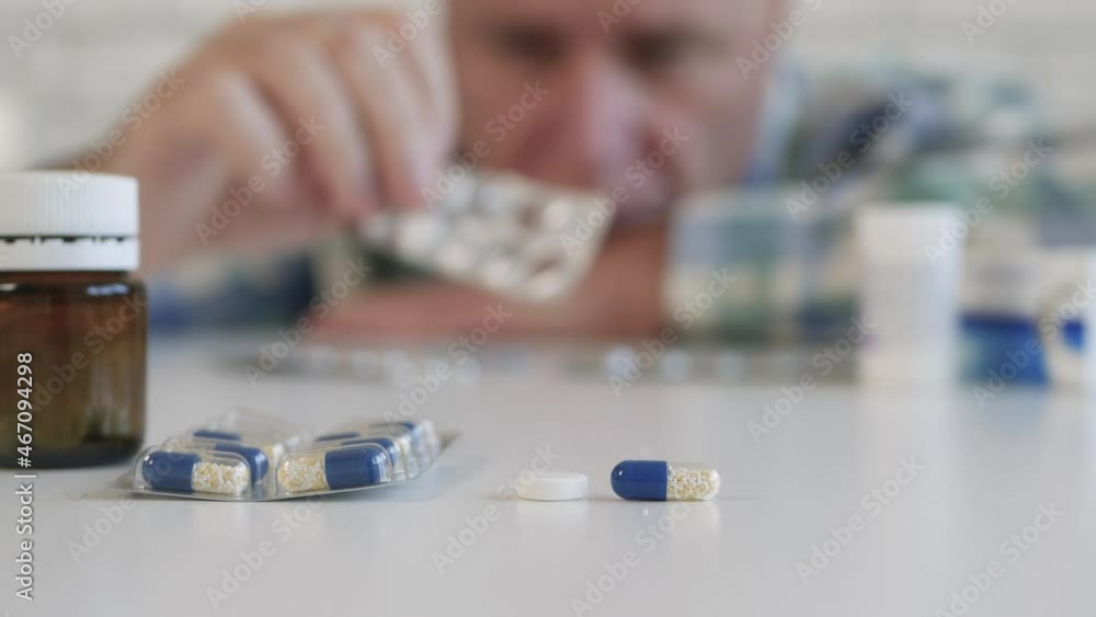 Suffering Person Taking Medicines. Man with a Serious Sickness Takes Home Treatment. Pills and Drugs, Addiction and Abuse Concept. Suffering Person Taking Medicines. Man with a Serious Sickness Takes Home Treatment. Pills and Drugs, Addiction and Abuse Concept.