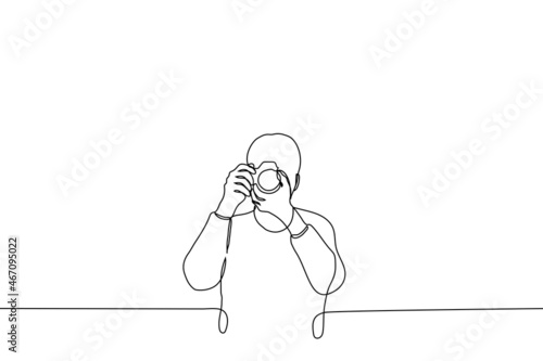 man stands with camera taking pictures of the viewer - one line drawing vector. concept of amateur or professional photographer, journalist reporter