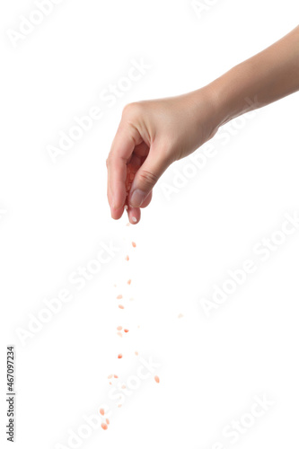 Hand sprinkle pink salt on white background