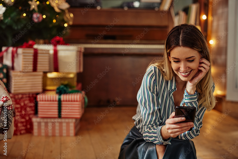 Smiling woman using phone at Christmastime